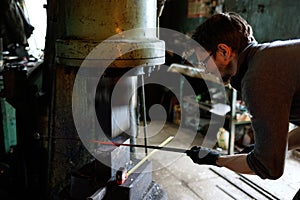 Blacksmith forging by using pneumatic hammer.