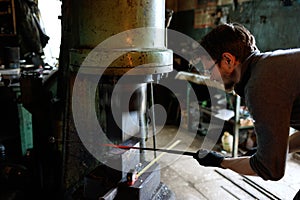 Blacksmith forging by using pneumatic hammer.