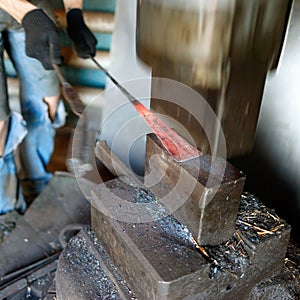 Blacksmith forging by using pneumatic hammer.