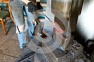 Blacksmith forging by using pneumatic hammer.