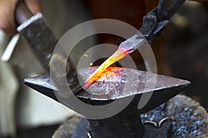 Blacksmith hammering hot metal arrow