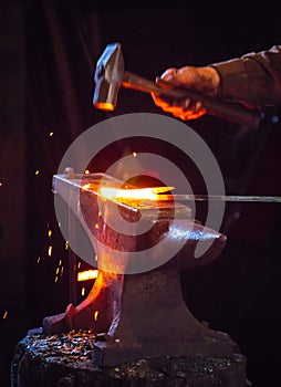 Blacksmith hammering a hot metal rod