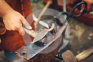 Blacksmith hammering a metal rod