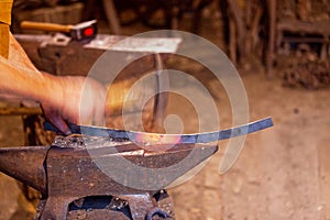 Blacksmith hammering a piece of molten iron