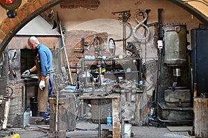 Blacksmith heats iron in a furnace. young traditional Blacksmith working with open fire The blacksmith making flames in smithy