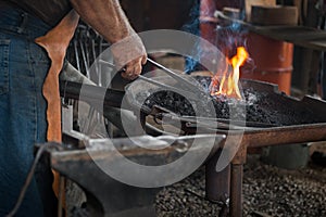 Blacksmith Heats Work in Fire