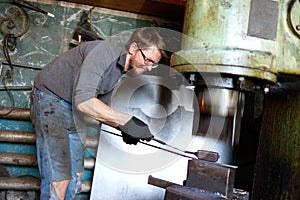 Blacksmith forging by using pneumatic hammer.
