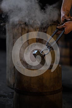 blacksmith holding iron work in forge