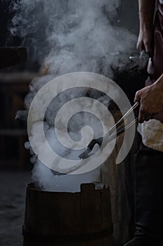 blacksmith holding iron work in forge