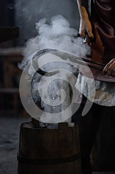 blacksmith holding iron work in forge