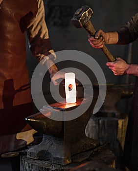 blacksmith holding iron work in forge