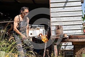 Blacksmith lighting a blowtorch in the backyard of his shop