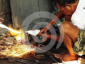 Blacksmith making a tools at his workshop