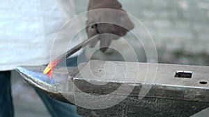 Blacksmith manually forging the heated metal