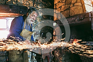 The blacksmith manually forging the molten metal