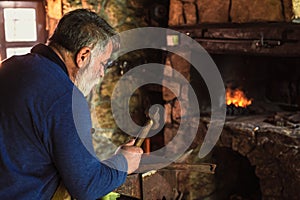 Blacksmith manually forging the molten metal