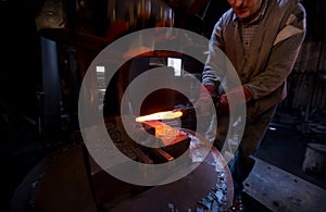 Blacksmith manually forging the molten metal