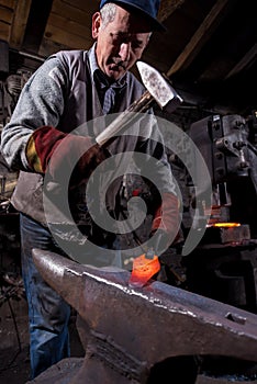 Blacksmith manually forging the molten metal