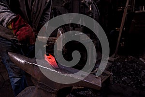 Blacksmith manually forging the molten metal