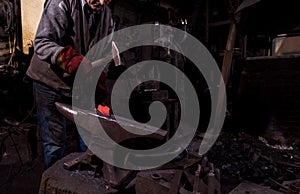 Blacksmith manually forging the molten metal