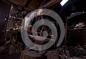 Blacksmith manually forging the molten metal