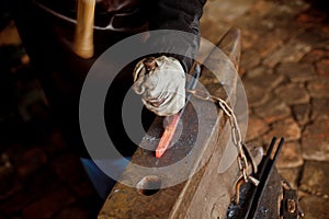 The blacksmith manually forging the molten metal