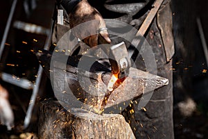 The blacksmith manually forging the molten metal on the anvil