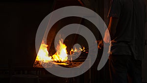 The blacksmith manually forging the molten metal on the anvil