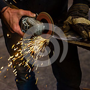 The blacksmith manually forging the molten metal on the anvil