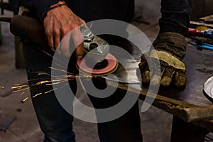 The blacksmith manually forging the molten metal on the anvil