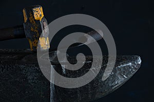 The blacksmith manually forging the molten metal on the anvil in