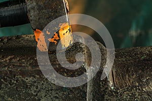 The blacksmith manually forging the molten metal on the anvil in