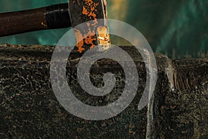 The blacksmith manually forging the molten metal on the anvil in