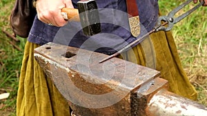 The blacksmith manually forging the molten metal on the anvil in smithy.