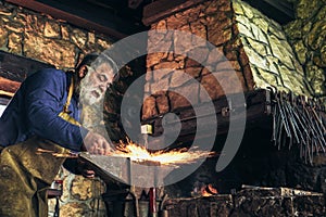 The blacksmith manually forging the molten metal photo