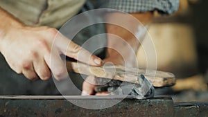 A blacksmith with a metal brush cleans the workpiece from scale and debris. Artisan craftsmanship