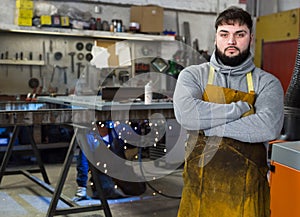 Blacksmith in metalworking workshop