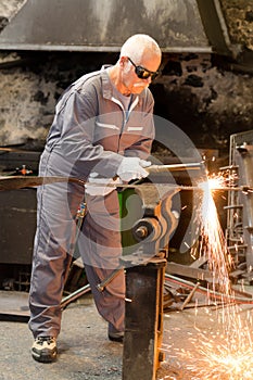 Blacksmith pounding hot iron to make into shovel