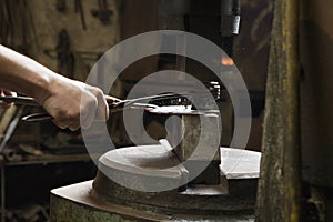 Blacksmith Shaping Metal In Workshop