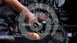 Blacksmith shaping the molten metal with hammer