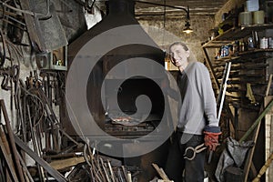 Blacksmith Standing By Forge In Workshop