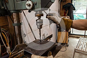 Blacksmith uses drill press in garage