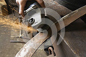 Blacksmith Using Angle Grinder On Edge Of Metal Tool