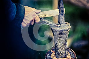 Blacksmith at work, making a hook