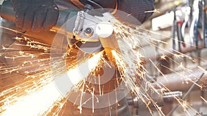 Blacksmith worker in forg making detail with circular saw