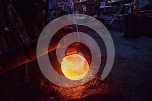 Blacksmith workers using mechanical hammer at workshop