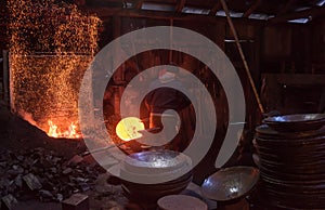 Blacksmith workers using mechanical hammer at workshop