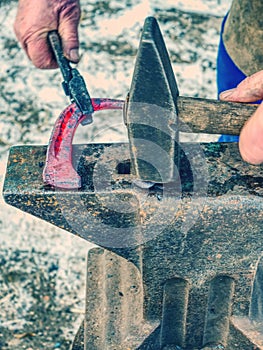 Blacksmith working to finalize horseshoe