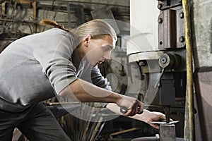Blacksmith Working In Workshop