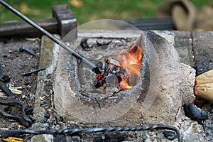 Blacksmithing, a red-hot piece of iron in a forge furnace